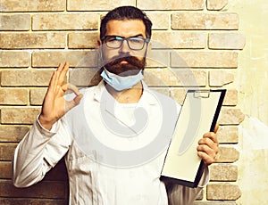 Bearded brutal caucasian doctor or postgraduate student with clipboard