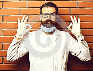 Bearded brutal caucasian doctor or postgraduate student in gloves