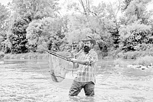 Bearded brutal fisher catching trout fish with net. If fish regularly you know how rewarding and soothing fishing is