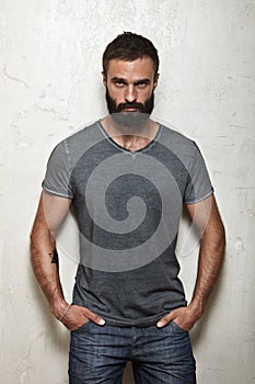 Bearded brutal guy wearing blank grey t-shirt