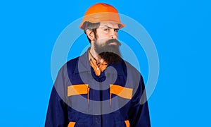 Bearded builder or architect in uniform and safety helmet. Construction worker in hard hat.