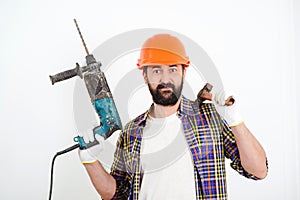 Bearded builder working with hammer and drill. Builder with professional tools