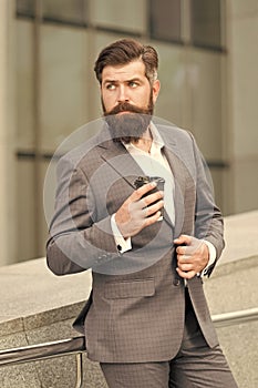 bearded businessman drink coffee to go. formal man in office suit drinking coffee from paper cup. good morning coffee
