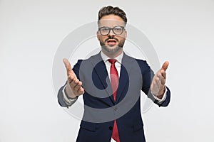 Bearded businessman with glasses gesticulating and showing with hands