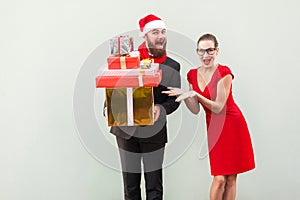 Bearded businessman holding many gift box, woman shows his hands