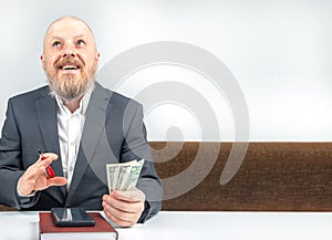 bearded businessman offers payment for work with money against the background of the hourglass. concept of value of time to pay