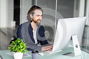 Bearded businessman working with computer in office