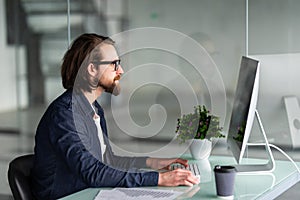 Bearded businessman working with computer in office