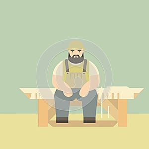 Bearded carpenter sitting on bench with saw and wood planks. Craftsman in apron resting at workbench in workshop