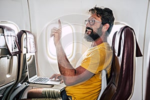 Bearded caucasian adult man sit down inside the airplane flight asking for hostess help -modern internet connection onboard