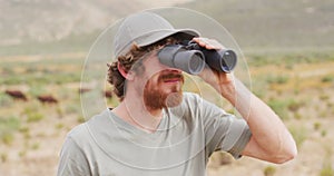 Bearded caucasian male survivalist looking to distance with binoculars in wilderness