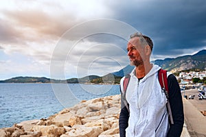 Bearded caucasian man, traveler walking along the marina