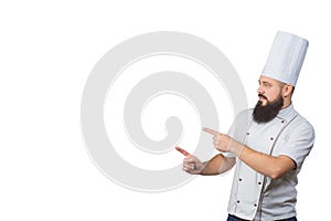 Bearded chef cook pointing with his fingers isolated on white background, copy space on side. photo