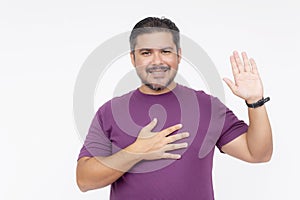 A bearded chubby man smiling while making a solemn oath. Wearing a purple waffle shirt. Half body photo isolated on white