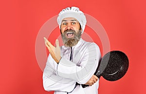 Bearded cook uniform Man hold cooking pan. Cooking like pro. Easy cheap tasty meals prepared at home. Be extra careful