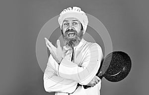 Bearded cook uniform Man hold cooking pan. Cooking like pro. Easy cheap tasty meals prepared at home. Be extra careful