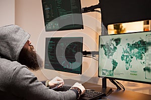 Bearded cyber criminal typing on computer