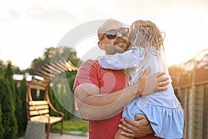 A bearded dad hugs daughter tightly, soothing and sympathizing with his child