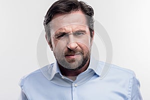 Bearded dark-haired man feeling angry after some arguments at work