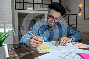 Bearded dark-haired man with papers looking involve dand interested