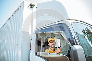 bearded delivery man with thumbs up driving goods truck