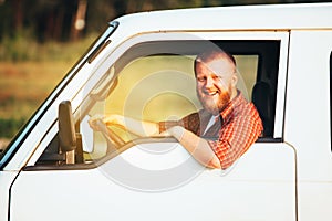 Bearded driver in plaid shirt driving his car