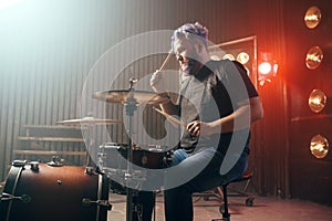 Bearded drummer with colorful hair, rock performer