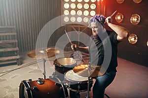 Bearded drummer with colorful hair, rock performer