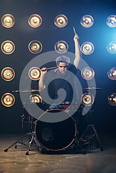 Bearded drummer with colorful hair on the stage