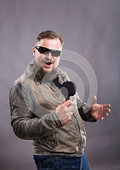 Bearded emotional rock singer with microphone studio portrait,