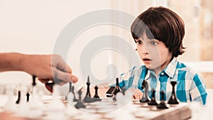 Bearded Father and Son Playing Chess on Table.