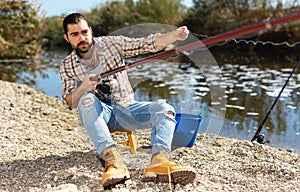 Bearded fisherman prepares fishing gear