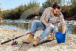 Bearded fisherman prepares fishing gear