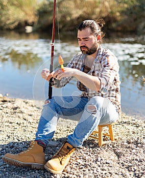 Bearded fisherman prepares fishing gear