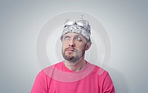 Bearded funny man in a cap of aluminum foil