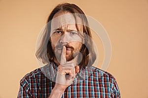 Bearded ginger man frown and showing silence gesture