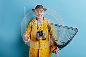 Bearded good looking old man holding fish tank and rod