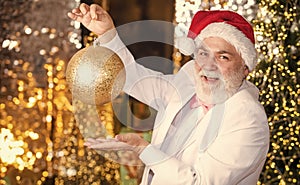 Bearded grandfather senior man celebrate christmas. Kind grandpa with toy. Sparkling decorations. Decorating home