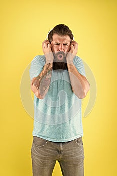Bearded guy dislike music. Irritating sound. Man listening music wireless headphones. Equalizer settings. Awful sound