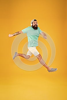 Bearded guy enjoy music. Impetuous movement. Hipster dancing jumping headphones gadget. Inspiring song. Music library