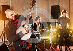 Bearded guy soloist playing guitar in studio