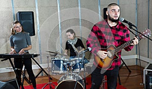 Bearded guy soloist playing guitar in studio