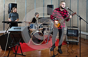 Bearded guy soloist playing guitar in studio