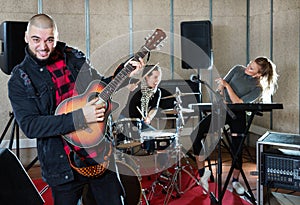 Bearded guy soloist playing guitar in studio photo