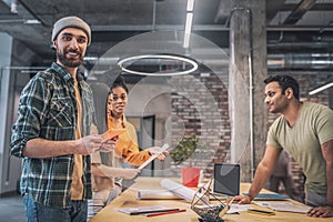 Bearded guy with tablet and colleagues in office photo