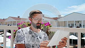 Bearded guy on vacation working on a tablet