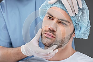 bearded handsome man in medical cap ready to facelift, photo