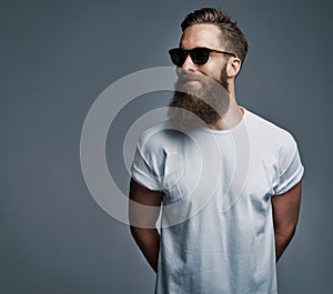 Bearded handsome man with sunglasses looking over