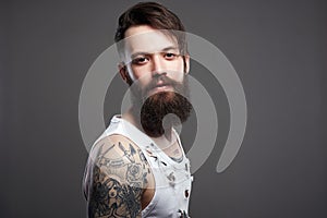 Bearded hipster. Boy with stylish haircut and tattoo