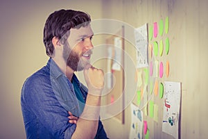 Bearded hipster looking at brainstorm wall